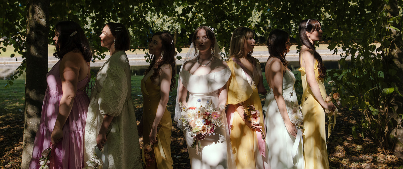 cinematic bridal party image by chris copeland weddings capturing chiaroscuro light outdoors with a bride and her bridesmaids